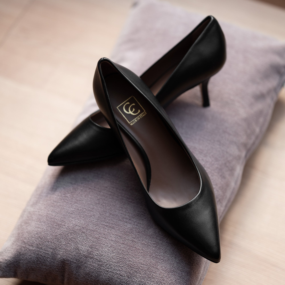 Black high-heeled shoes on a gray surface