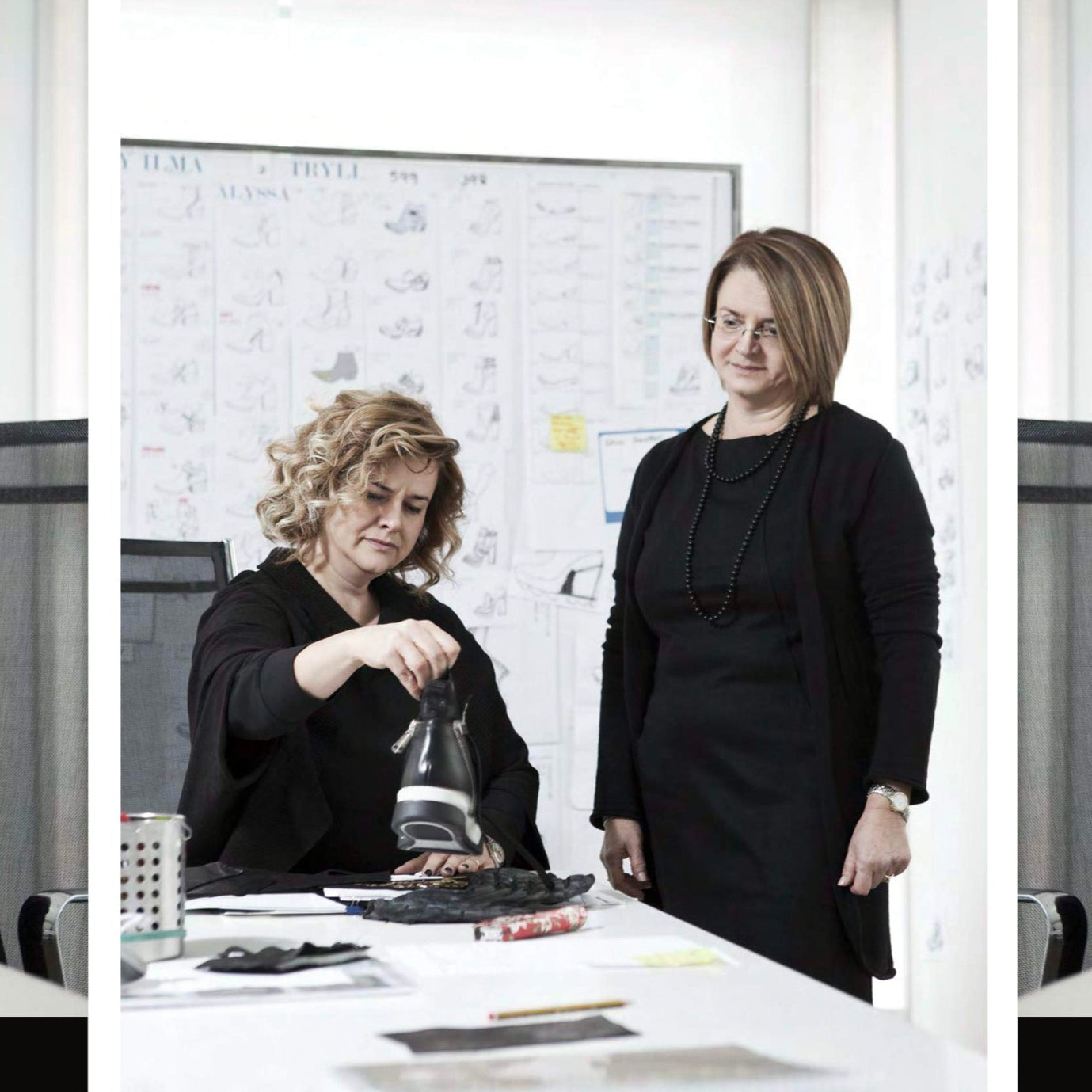 Two women in a professional setting, one pouring from a bottle into a glass.