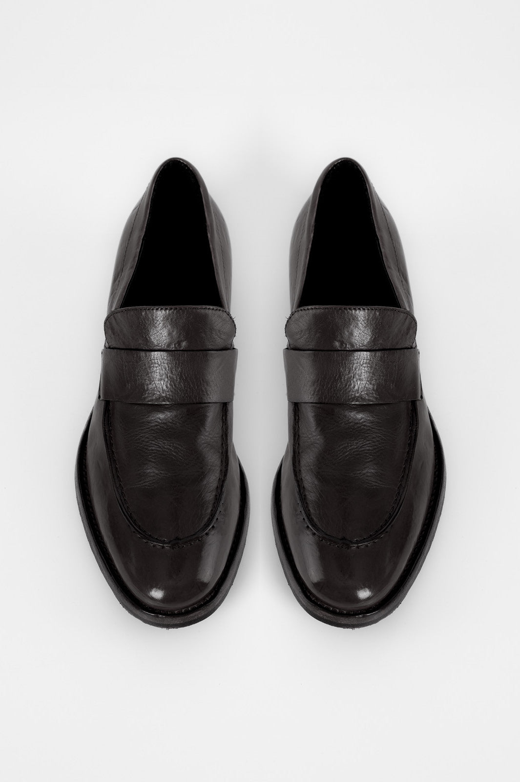 Pair of black leather loafers on a white background