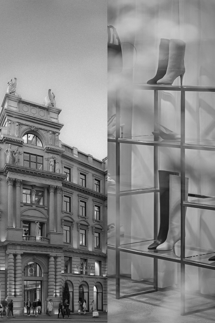 Shoe display in a store window with a classical building exterior.