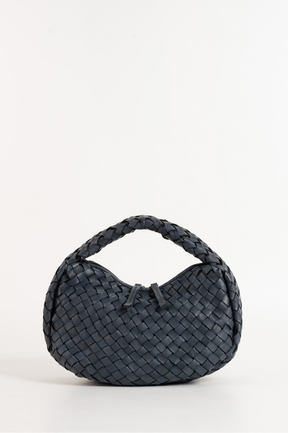Black woven handbag on a white background