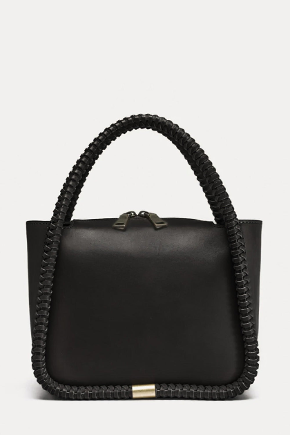 Black handbag with braided handle on a light gray background