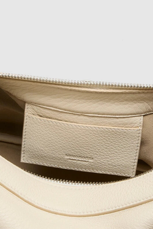 Close-up of a beige leather bag with a visible brand label.
