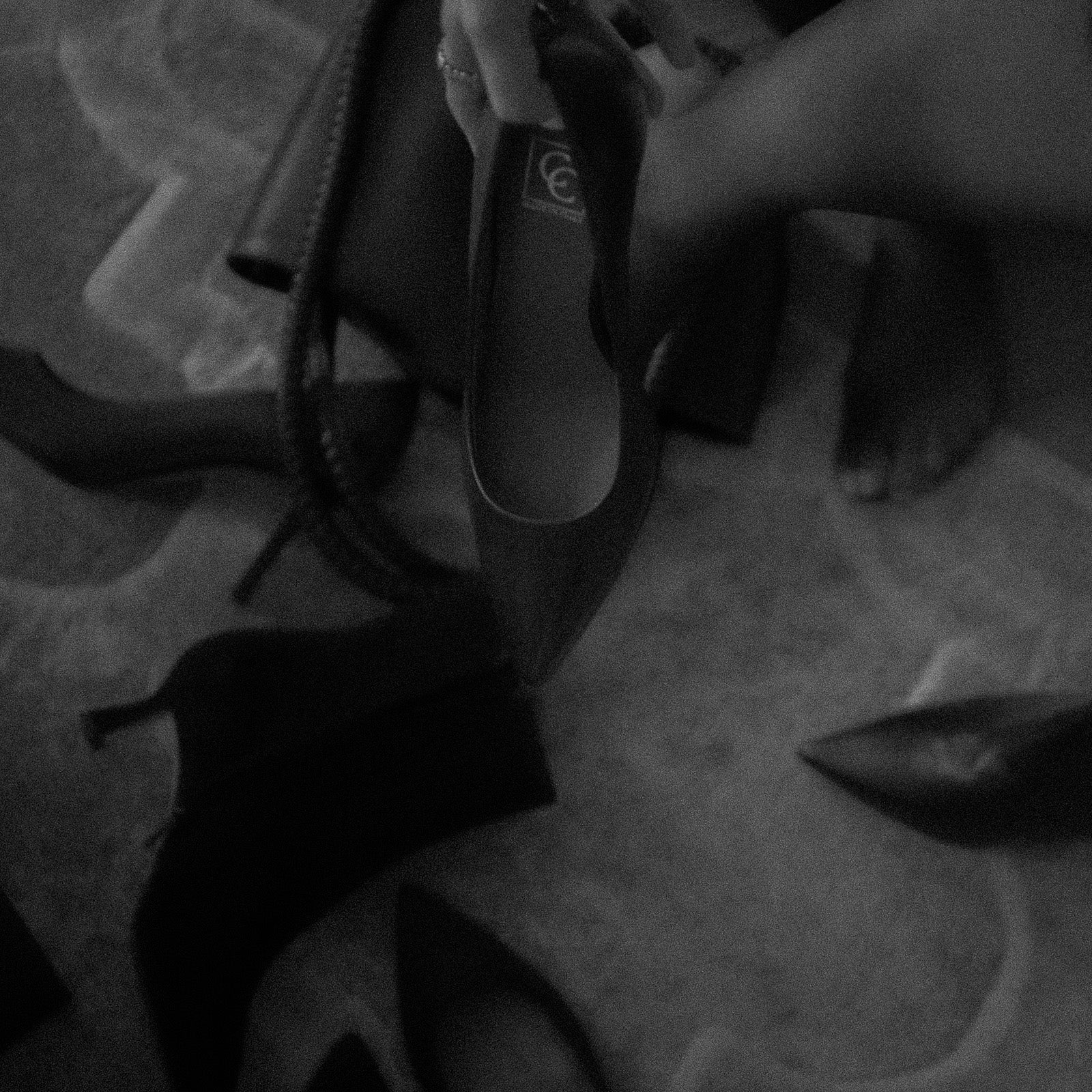 Black high-heeled shoes on a textured surface