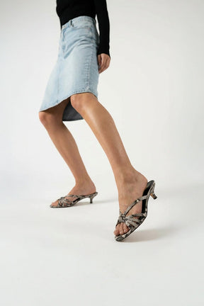 Person wearing high-heeled shoes on a plain background
